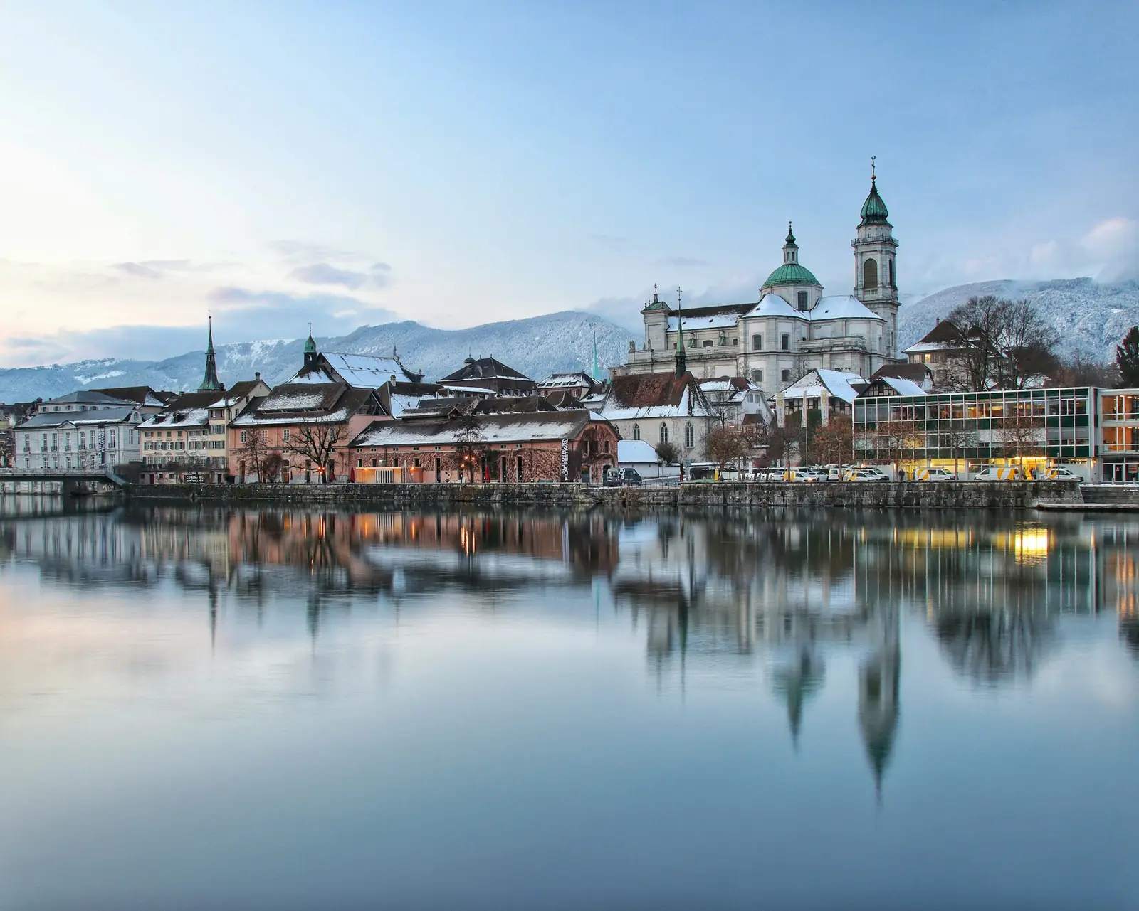 Solothurn an der Aare im Winter, die Altstadt spiegelt sich im Wasser, dahinter der Jura