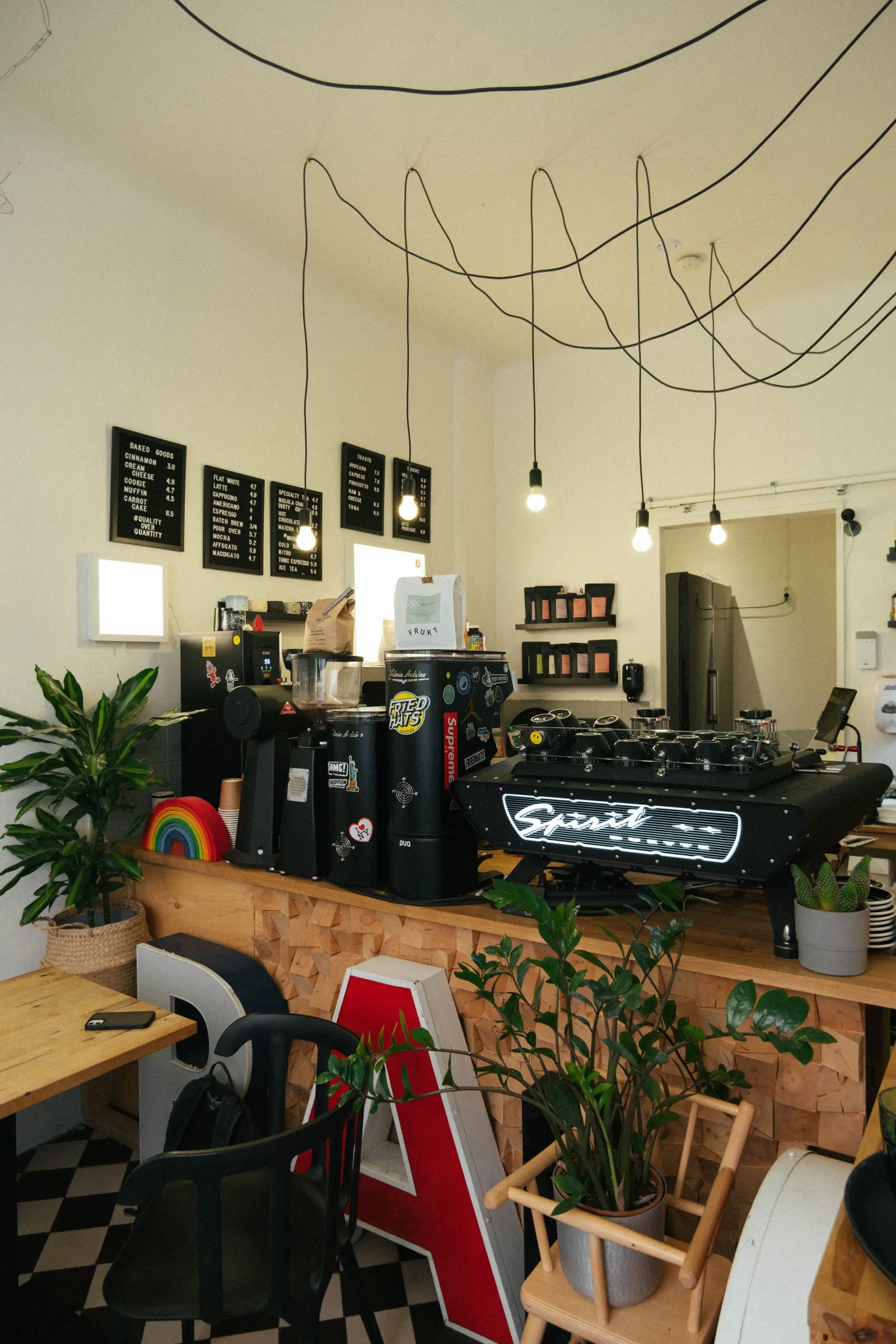 Kaffeebar mit Hängelampen, Espressomaschine und Pflanzen